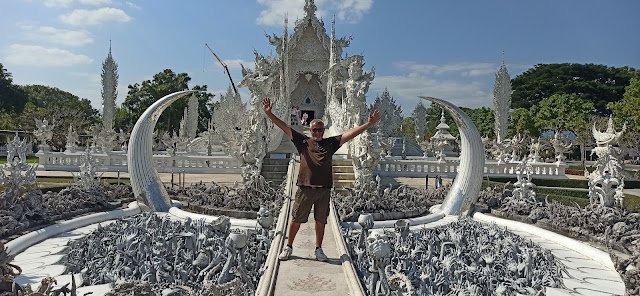 Viajero en el Puente de la Reencarnación del Templo Blanco de Chiang Rai (Wat Rong Khun), una estrecha pasarela que cruza sobre cientos de manos blancas que emergen del infierno simbolizando el deseo, la codicia y la tentación. Una experiencia única que te hace reflexionar sobre la vida y las decisiones.