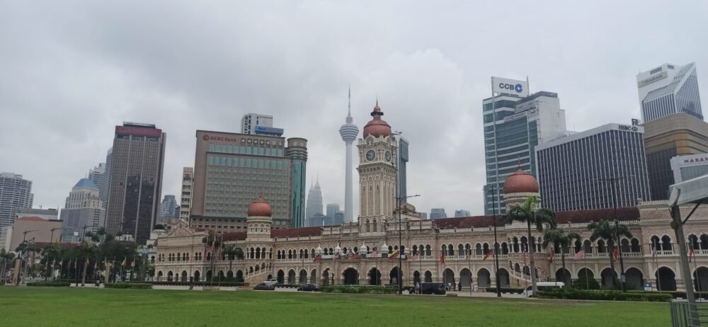 Vista de la Plaza Merdeka (Dataran Merdeka) en Kuala Lumpur, el lugar donde Malasia declaró su independencia en 1957, con el icónico Edificio Sultan Abdul Samad de estilo morisco en primer plano y la moderna Torre de telecomunicaciones KL (Menara Kuala Lumpur) de 421 metros al fondo. Un contraste perfecto entre la historia y la modernidad que define viajar a Malasia.