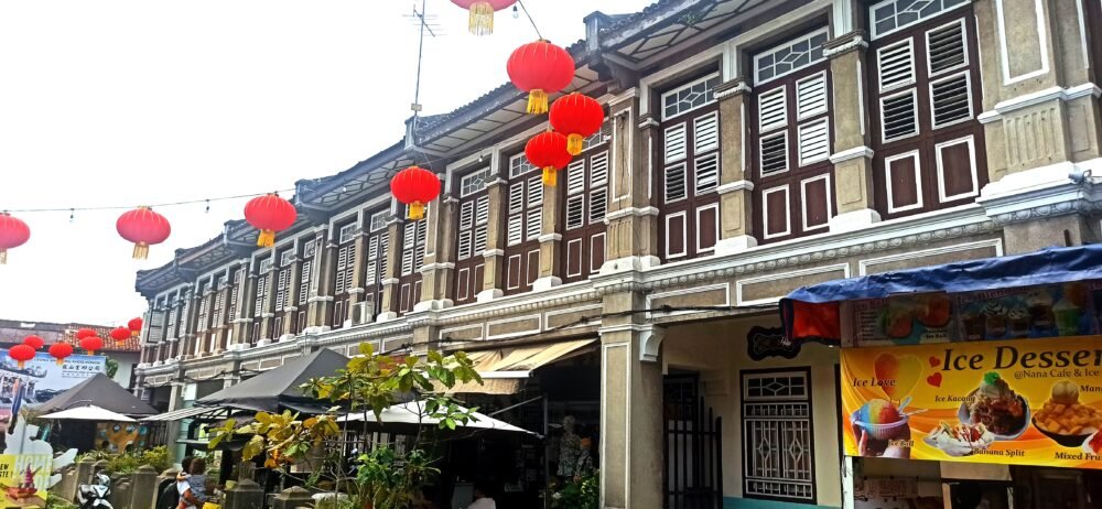 Vista de las típicas casas coloniales de Georgetown, Penang, con sus fachadas de colores y contraventanas de madera. Una imagen emblemática del centro histórico de la ciudad y una parada obligatoria al Visitar GeorgeTown.