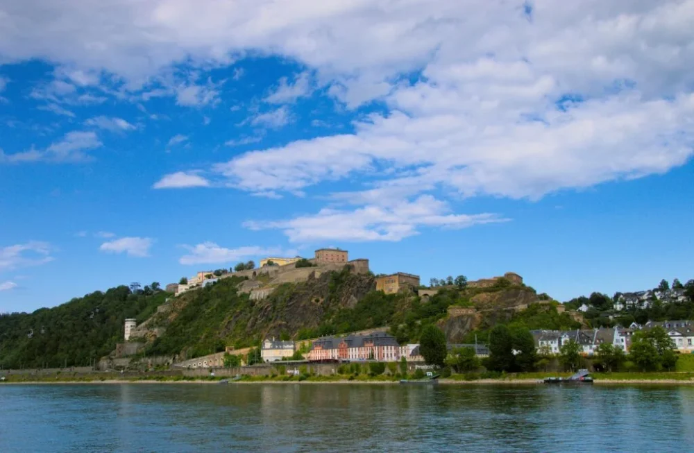 Vista de la imponente Fortaleza de Ehrenbreitstein en Koblenz desde el río Rin, una parada histórica imprescindible en tu roadtrip por el oeste de Alemania.