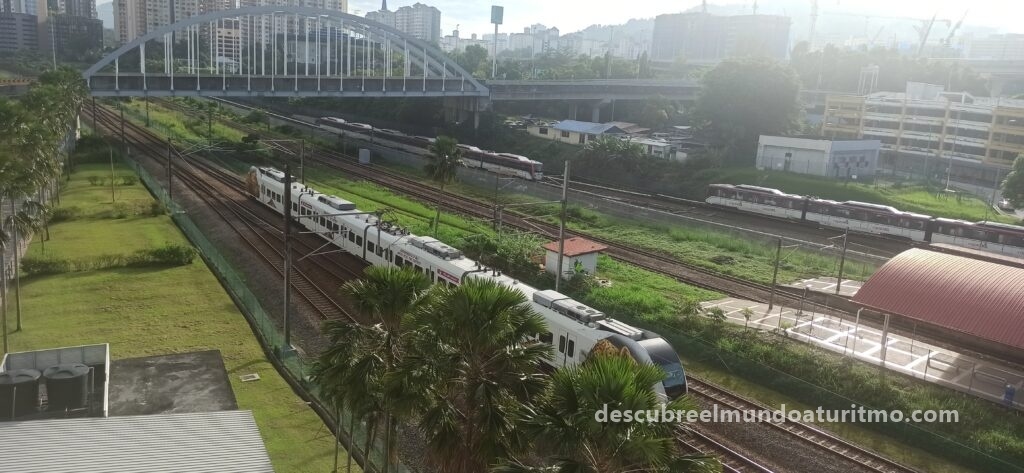 "Vista panorámica del skyline de Kuala Lumpur con las Torres Petronas al atardecer" "Monorraíl elevado cruzando el centro de Kuala Lumpur" "Estación de autobuses gratuitos en Kuala Lumpur con indicaciones multilingües" "Tren KTM Komuter llegando a la estación de Kuala Lumpur Sentral" "Mapa interactivo del sistema BTS y metro de Kuala Lumpur para turistas" 