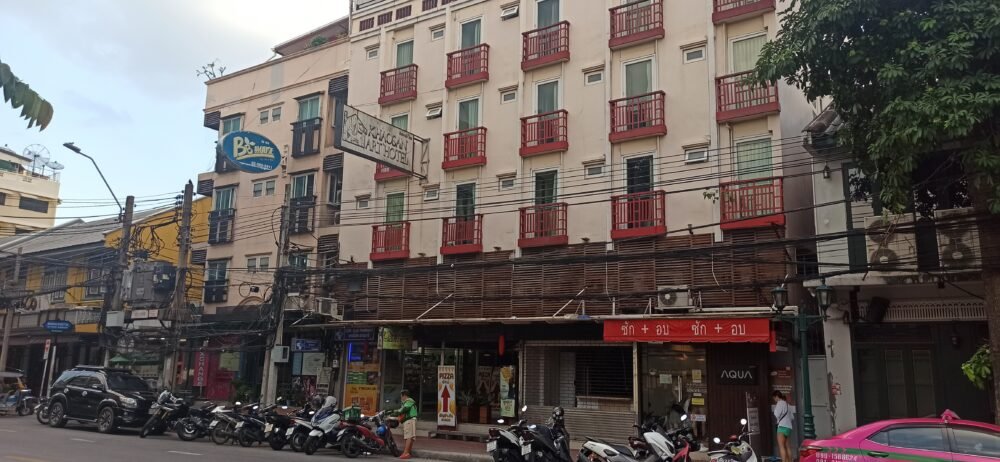 Entrada del Khaosan Art Hotel en Bangkok desde la acera de enfrente, mostrando la fachada del edificio y el ambiente urbano de la calle de Bangkok