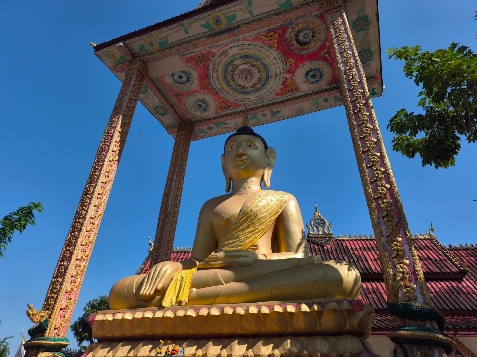 Estátua dorada de Buda sentado en postura de meditación en Wat That Khao, Vientián. La imagen muestra al Buda sobre un pedestal ornamentado, con el templo vacío y silencioso a su alrededor, solo iluminado por la luz natural que entra por las puertas abiertas. Estátua dorada de Buda sentado en postura de meditación en Wat That Khao, Vientián. La imagen muestra al Buda sobre un pedestal ornamentado, con el templo vacío y silencioso a su alrededor, solo iluminado por la luz natural que entra por las puertas abiertas.