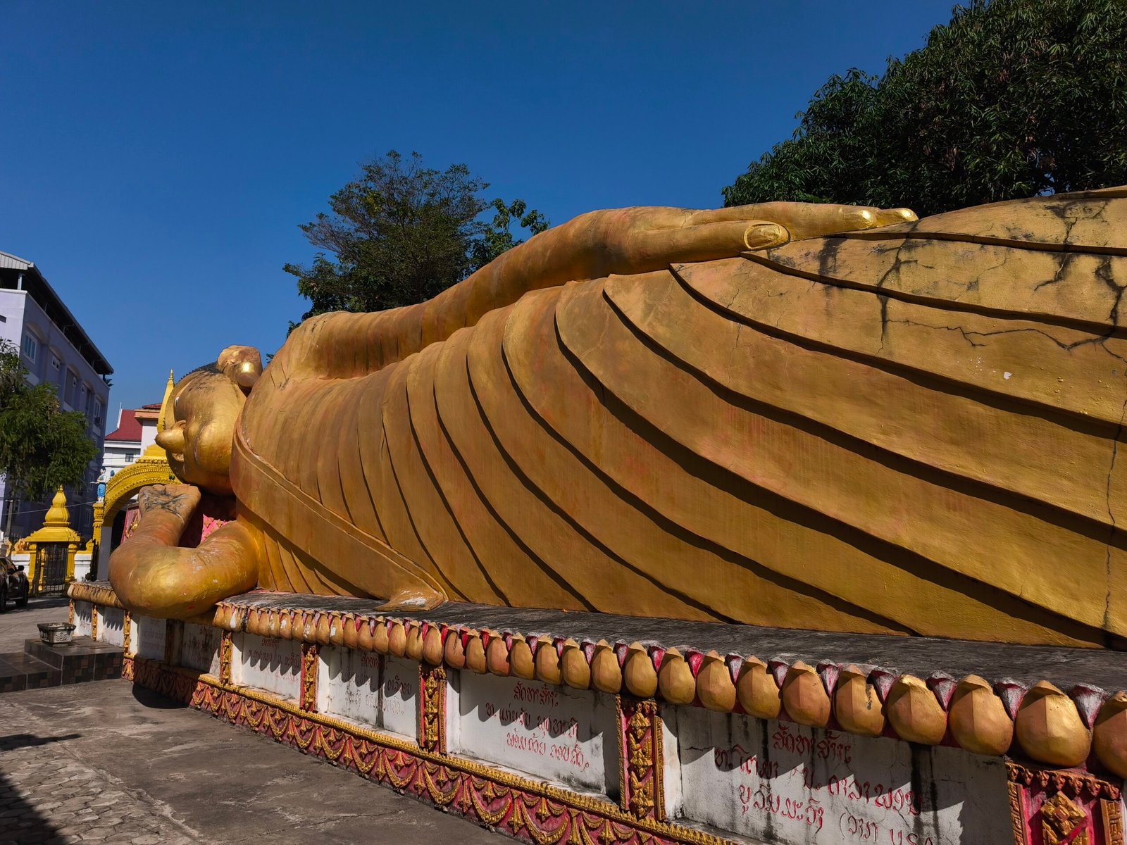 Impresionante estatua de Buda reclinado en el interior de Wat That Khao, Vientián. La imagen muestra el gran Buda dorado ocupando casi todo el espacio del templo, con un ambiente de absoluta soledad y silencio, sin turistas a la vista, transmitiendo una paz casi mística. Impresionante estatua de Buda reclinado en el interior de Wat That Khao, Vientián. La imagen muestra el gran Buda dorado ocupando casi todo el espacio del templo, con un ambiente de absoluta soledad y silencio, sin turistas a la vista, transmitiendo una paz casi mística.